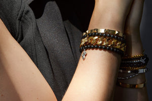 A wrist wearing a collection of bracelets in different sizes