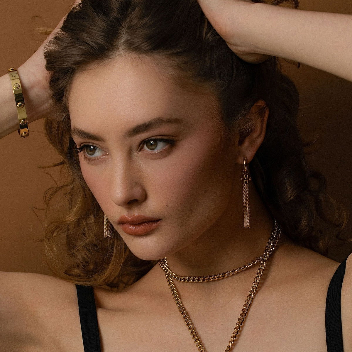 Model wearing Odyssée Tassel Earrings in 14k gold-plated stainless steel. 