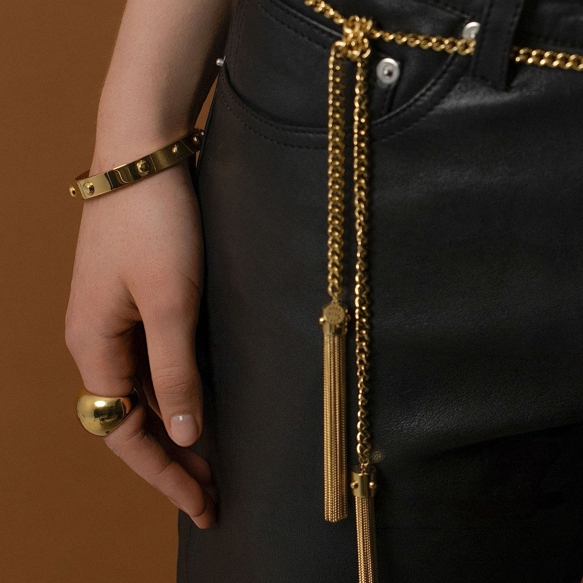 Model wearing Silk & Steel Odyssée Tassel Lariat as belt with Odyssée bangle in 14k gold-plated stainless steel.