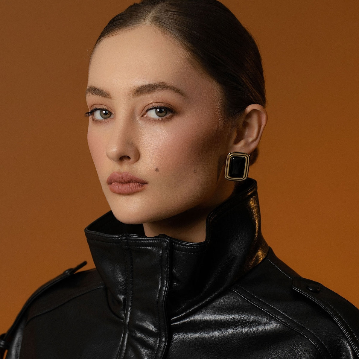 Model wears Silk & Steel statement Eclipse Earrings with black onyx in 14k gold-plated stainless steel.