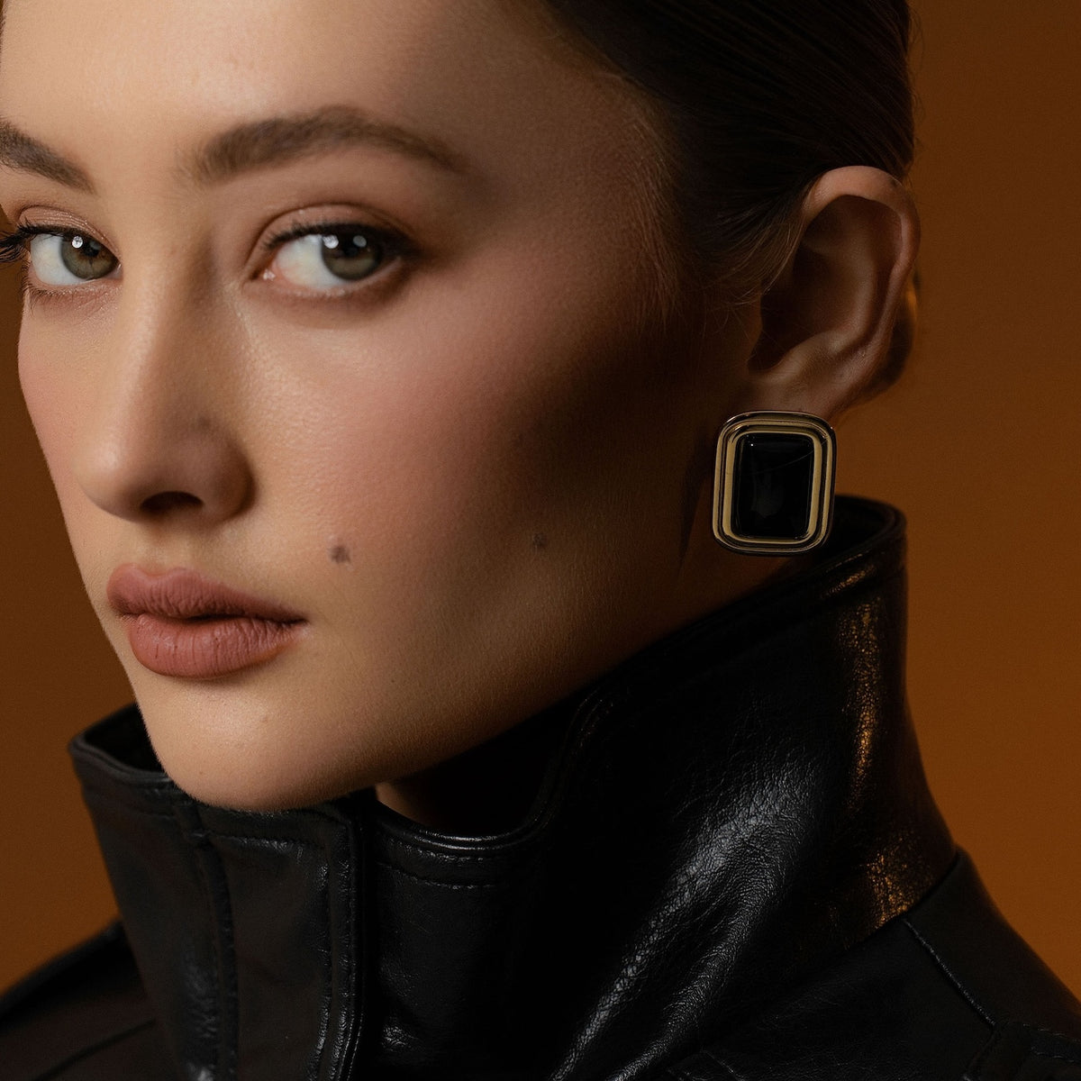 Model wearing Eclipse Statement Earrings with black onyx in 14k gold-plated stainless steel. 
