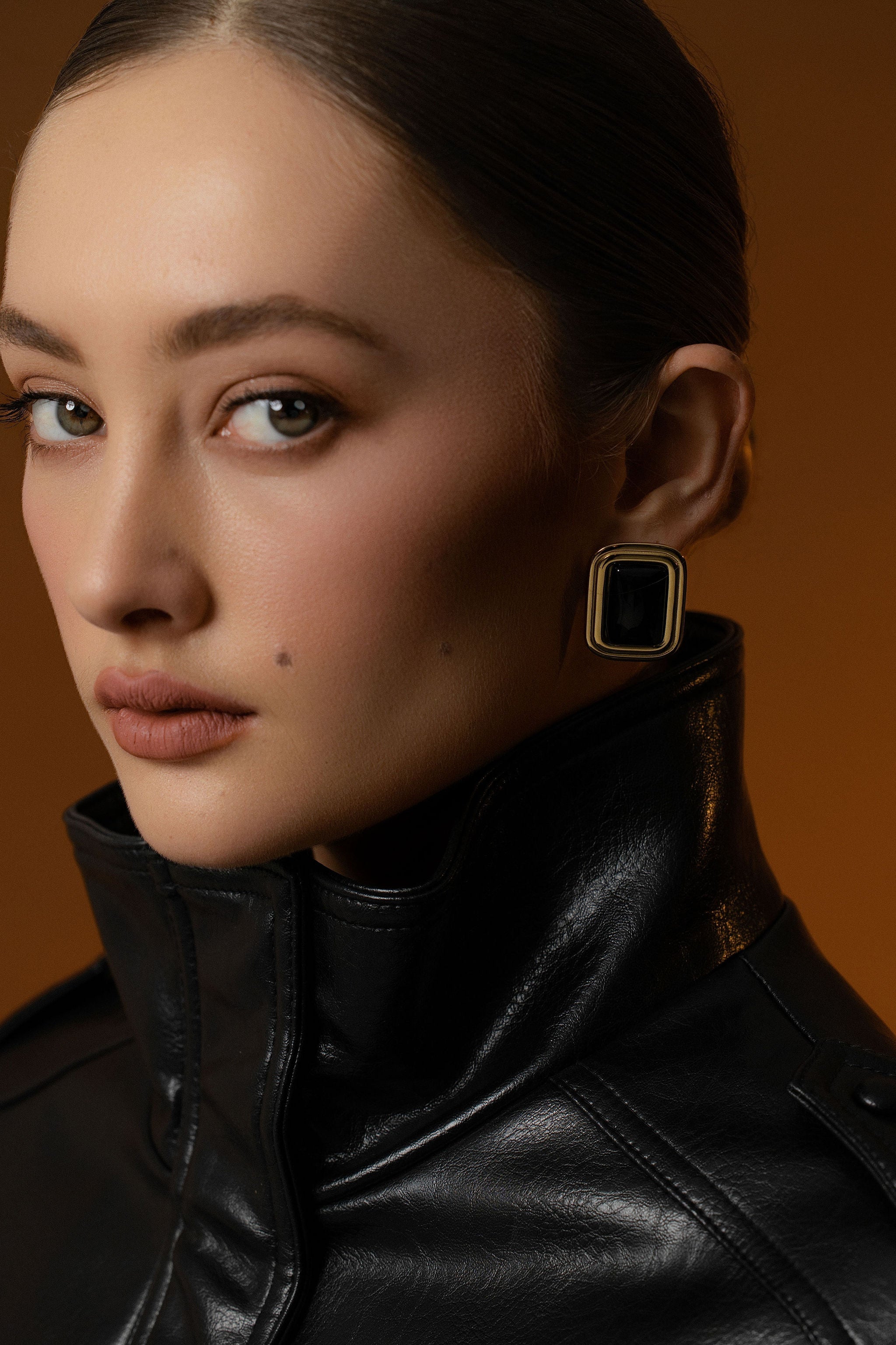 Model wears Eclipse Statement Earrings in 14k gold-plated stainless steel with black leather jacket