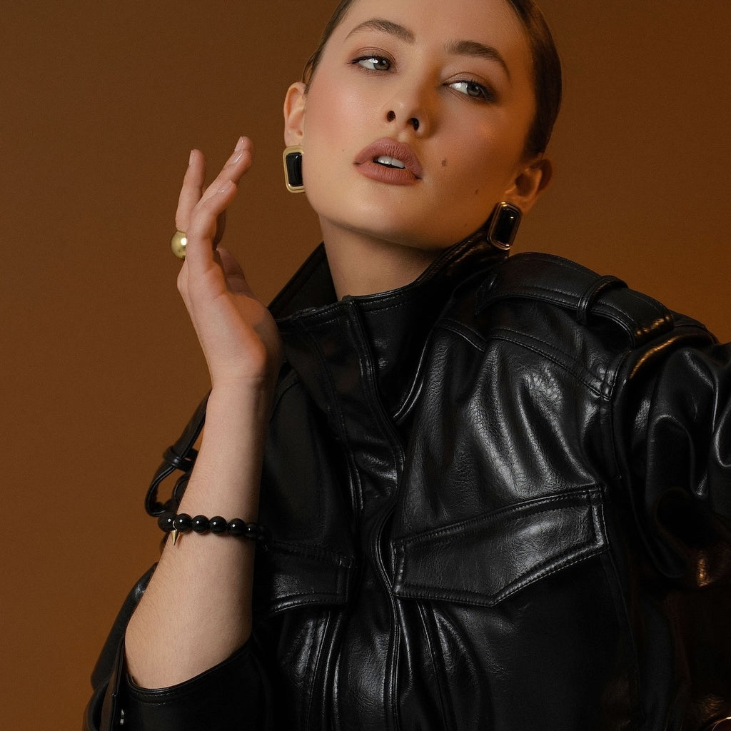 Model wearing Eclipse Statement Earrings with black onyx in 14k gold-plated stainless steel. 
