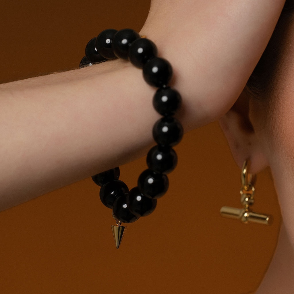Model wearing beaded Midnight Bracelet with black onyx in 14k gold-plated stainless steel. 