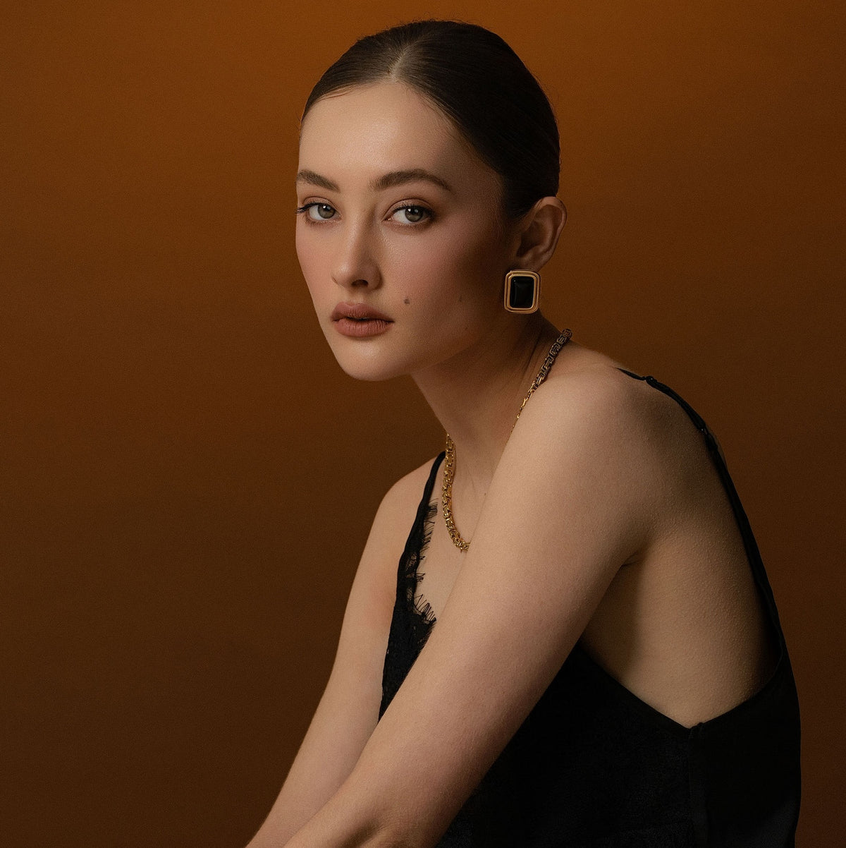 Model wears Silk & Steel statement Eclipse Earrings with black onyx in 14k gold-plated stainless steel.