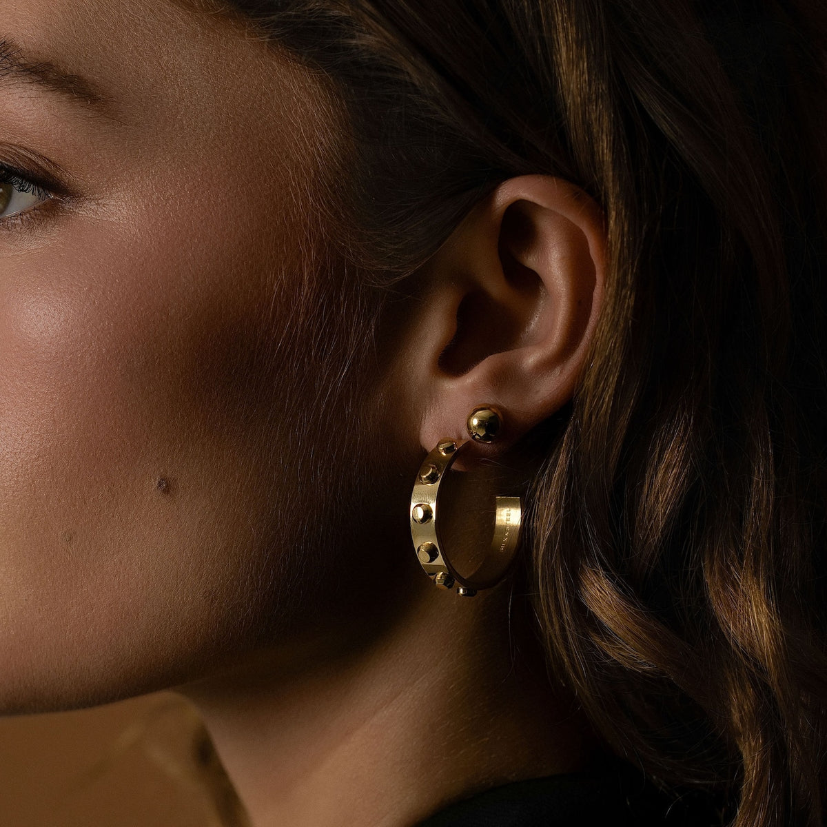 Model wears Silk & Steel Odyssée Hoops with Dome Studs in 14k gold-plated stainless steel.